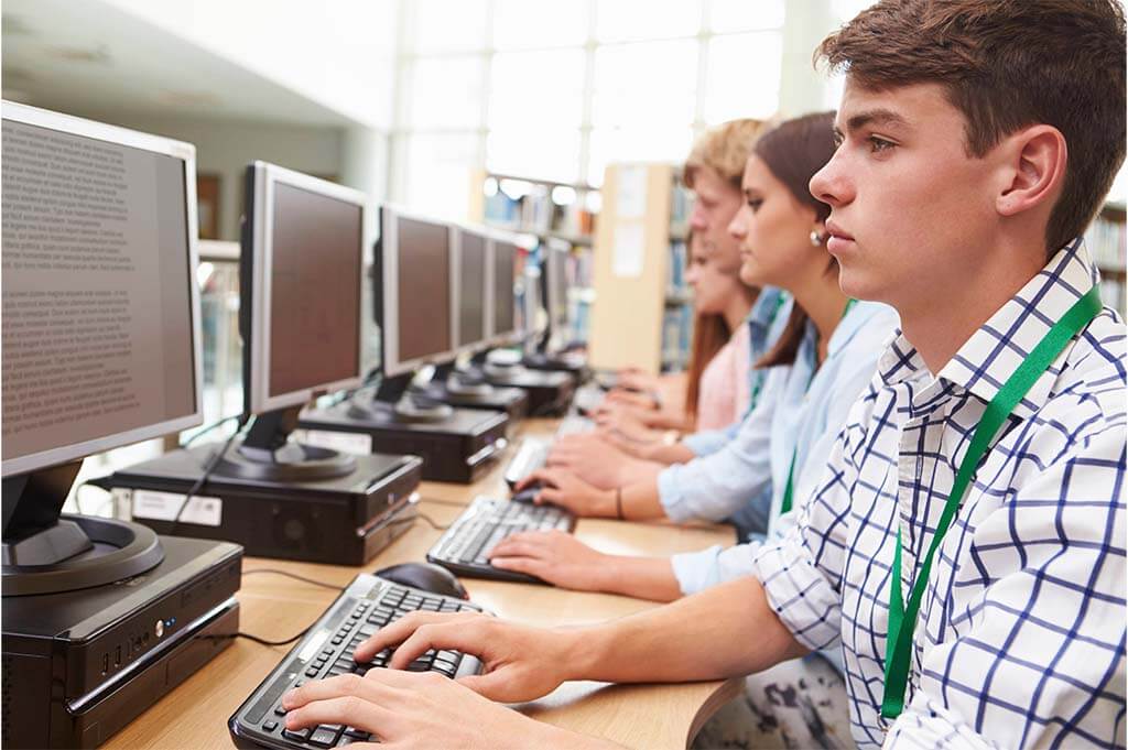 Schüler sitzen bei Prüfung am Computer
