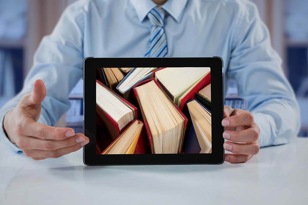 Lehrer hält ein Tablet mit Abbildung von Büchern - papierlose Schule
